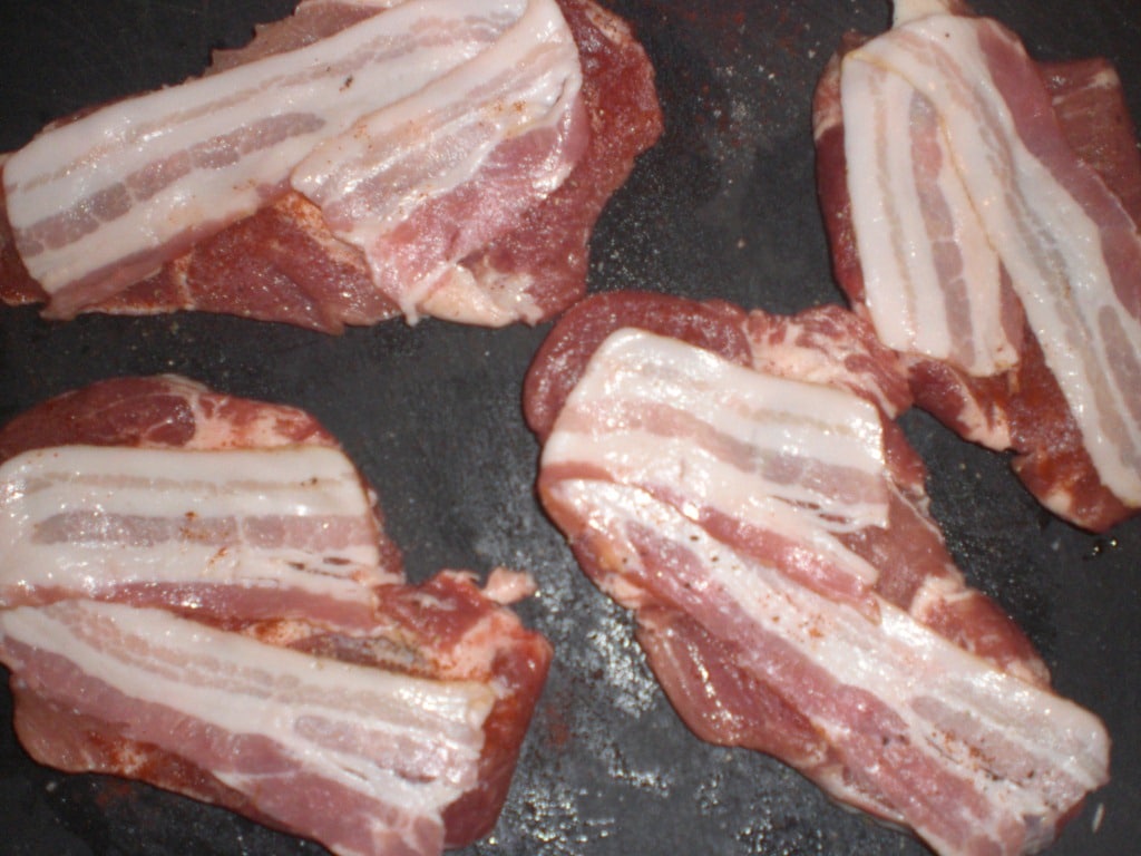 Læg bacon på koteletterne.