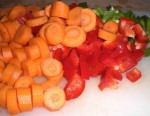 Skær gulerødder i skiver, og peberfrugt i tern.