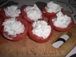 Fordel blandingen i de halverede, udhulede tomater.