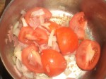 Tilsæt tomatbåde og løg.