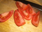 Skær tomater i kvarte.
