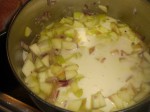 Hæld fløde, vand og bouillonterning ned til de svitsede løg- og æbletern.